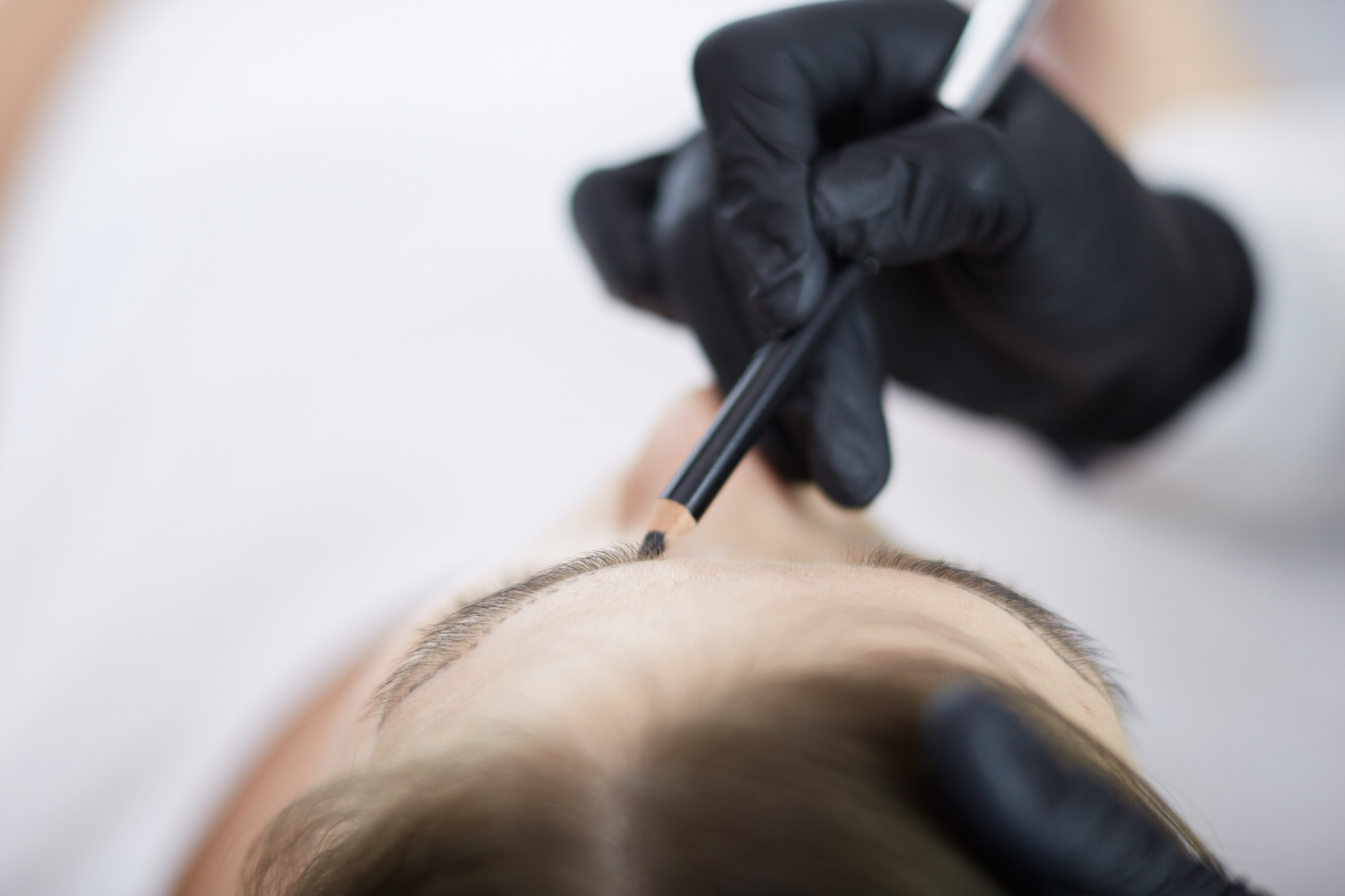 Cosmetologist applying permanent make up on eyebrows